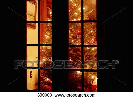 Illuminated Christmas tree seen through a window View Large Photo Image Stock Image - Illuminated Christmas tree seen through a window. Fotosearch