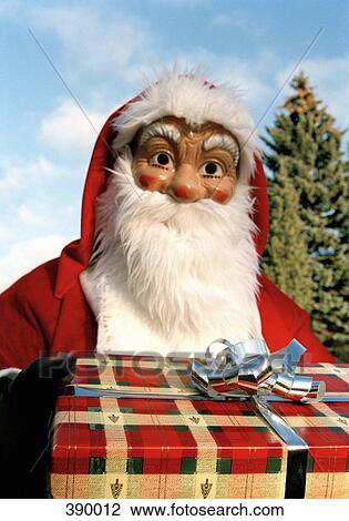 Santa Claus holding a present View Large Photo Image Stock Image - Santa Claus holding a present. Fotosearch