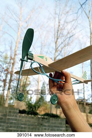 Man holding a rubber band model airplane View Large Photo Image Picture - Man holding a rubber band model airplane. Fotosearch