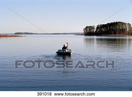 Man riding a pedal boat on a lake View Large Photo Image Stock Photo - Man riding a pedal boat on a lake. Fotosearch
