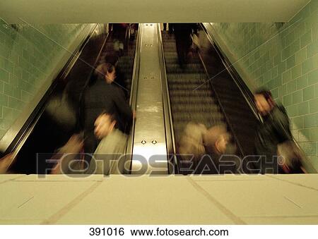 People moving up escalators at a train station View Large Photo Image Stock Photograph - People moving up escalators at a train station. Fotosearch