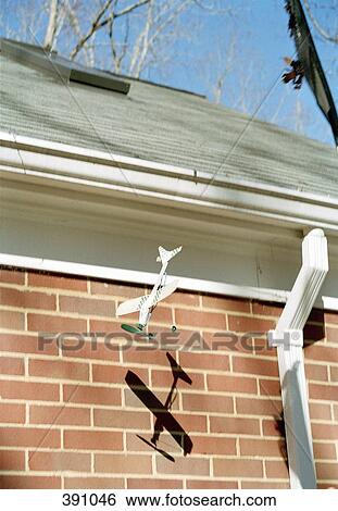 Rubber band model airplane flying next to a house View Large Photo Image Stock Photograph - Rubber band model airplane flying next to a house. Fotosearch