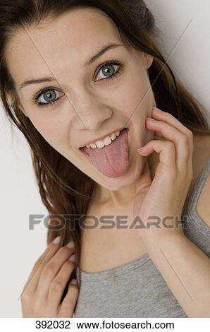 Young woman sticking out tongue View Large Photo Image Stock Image - Young woman sticking out tongue. Fotosearch