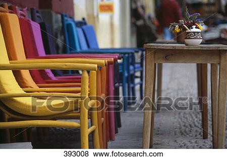 Stock Photo - Colorful chairs and wooden tables at an outdoor cafe, Peru. Fotosearch