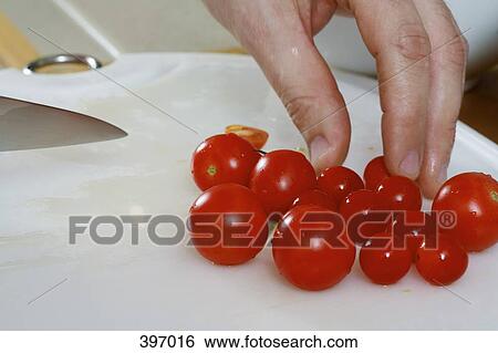 Stock Photograph - Cherry tomatoes on a chopping board. Fotosearch