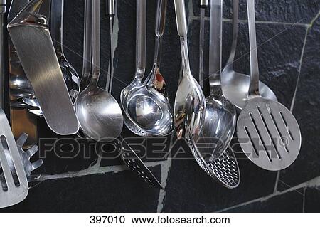 Kitchen utensils hanging from a wall View Large Photo Image Stock Image - Kitchen utensils hanging from a wall. Fotosearch