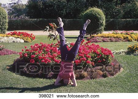 A woman doing a headstand in a park View Large Photo Image Stock Image - A woman doing a headstand in a park. Fotosearch