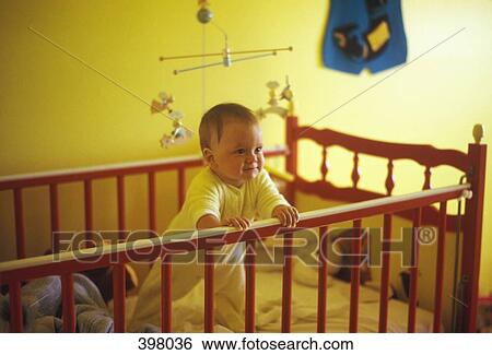 Baby boy standing up in his crib View Large Photo Image Stock Photograph - Baby boy standing up in his crib. Fotosearch