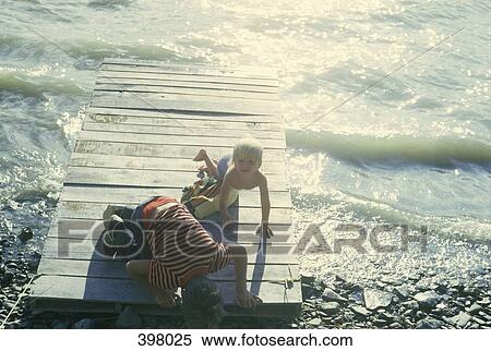 Father and son on a raft by the sea shore View Large Photo Image Stock Photography - Father and son on a raft by the sea shore. Fotosearch