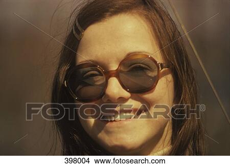 Portrait of a young woman wearing big sunglasses View Large Photo Image Picture - Portrait of a young woman wearing big sunglasses. Fotosearch