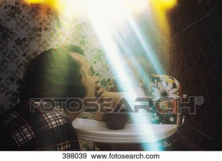 Stock Photo - Young boy sitting in a high chair and feeding chocolate to his dad. Fotosearch