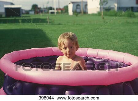 Young boy sitting in a wading pool View Large Photo Image Picture - Young boy sitting in a wading pool. Fotosearch