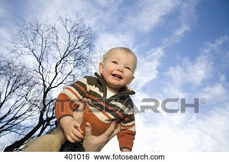 Stock Photograph - A young boy being lifted into the air. Fotosearch