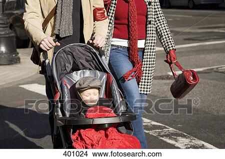 Midsection view of a couple pushing a pushchair View Large Photo Image Picture - Midsection view of a couple pushing a pushchair. Fotosearch