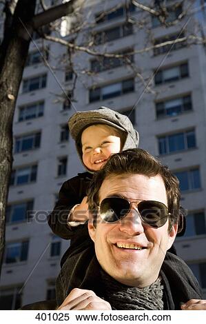 Young boy sitting on the shoulders of his father View Large Photo Image Stock Photography - Young boy sitting on the shoulders of his father. Fotosearch