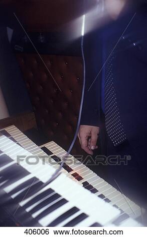 Stock Photograph - A man standing next to a keyboard. Fotosearch