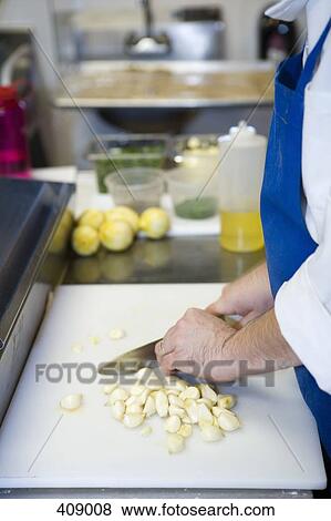 Chef chopping cloves of garlic View Large Photo Image Stock Photo - Chef chopping cloves of garlic. Fotosearch