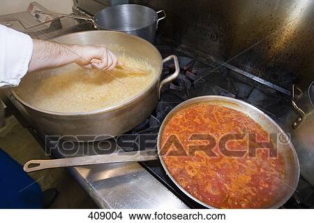 Chef stirring pots of food cooking on a stove View Large Photo Image Picture - Chef stirring pots of food cooking on a stove. Fotosearch