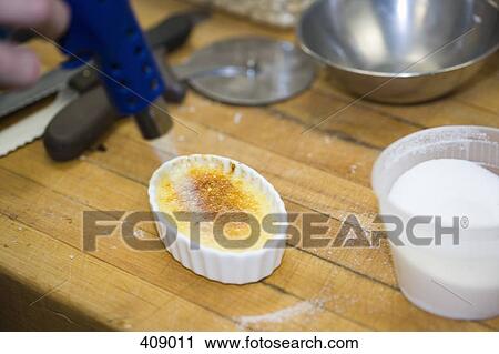 Chef using a kitchen torch to make creme brulee View Large Photo Image Stock Image - Chef using a kitchen torch to make creme brulee. Fotosearch