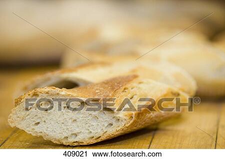 Sliced baguette on a cutting board View Large Photo Image Stock Image - Sliced baguette on a cutting board. Fotosearch