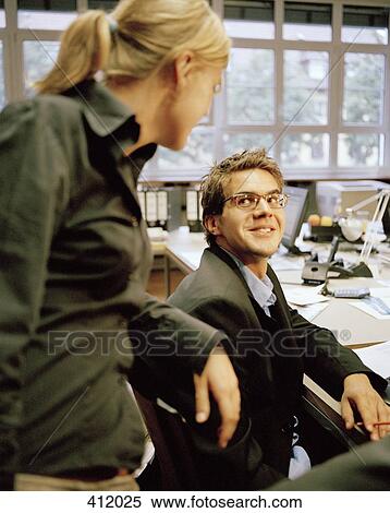 Office colleagues gathered at a desk View Large Photo Image Stock Photography - Office colleagues gathered at a desk. Fotosearch