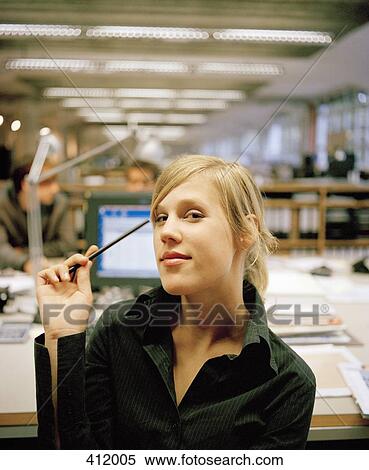 Portrait of a woman sitting at a desk in an office View Large Photo Image Stock Photography - Portrait of a woman sitting at a desk in an office. Fotosearch