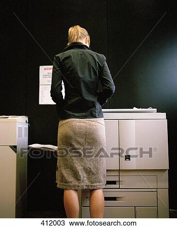 Woman standing at a photocopier View Large Photo Image Stock Image - Woman standing at a photocopier. Fotosearch
