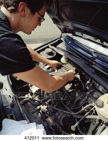 Young man checking a car battery View Large Photo Image Stock Image - Young man checking a car battery. Fotosearch