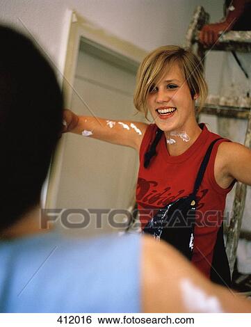 Young woman stepping down from a ladder during home improvements View Large Photo Image Stock Photograph - Young woman stepping down from a ladder during home improvements. Fotosearch