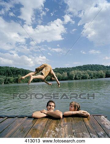 A young man diving into a lake with friends View Large Photo Image Stock Image - A young man diving into a lake with friends. Fotosearch