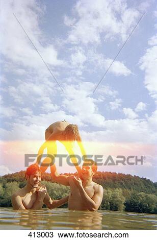 Stock Image - Friends messing about in a lake. Fotosearch