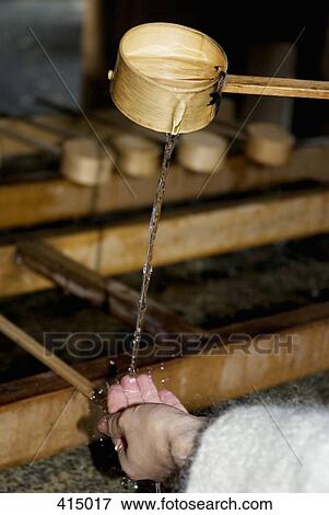 Stock Photo - Pouring water from a wooden ladle. Fotosearch
