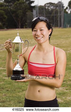 Female athlete holding a trophy View Large Photo Image Stock Photography - Female athlete holding a trophy. Fotosearch