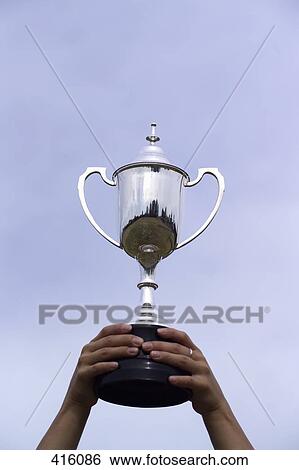 Female athlete holding up a trophy View Large Photo Image Stock Photograph - Female athlete holding up a trophy. Fotosearch