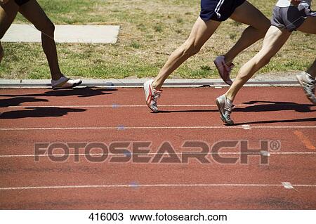 Stock Image - Group of male athletes running on a track. Fotosearch