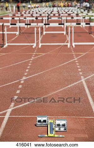 Hurdles arranged on a running track behind starting blocks View Large Photo Image Stock Image - Hurdles arranged on a running track behind starting blocks. Fotosearch