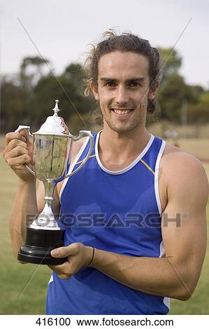 Male athlete holding a trophy View Large Photo Image Stock Image - Male athlete holding a trophy. Fotosearch
