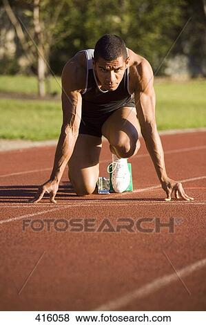 Male athlete in starting blocks on a running track View Large Photo Image Stock Photo - Male athlete in starting blocks on a running track. Fotosearch