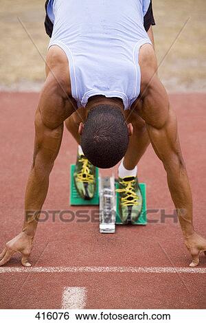 Male athlete in starting blocks on a running track View Large Photo Image Stock Photograph - Male athlete in starting blocks on a running track. Fotosearch
