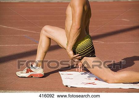 Male athlete stretching on the edge of a running track View Large Photo Image Stock Image - Male athlete stretching on the edge of a running track. Fotosearch