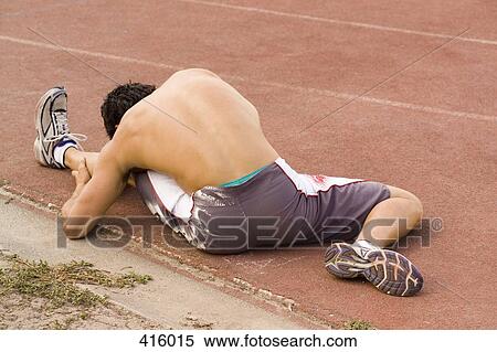 Male athlete stretching on the edge of a running track View Large Photo Image Stock Photography - Male athlete stretching on the edge of a running track. Fotosearch
