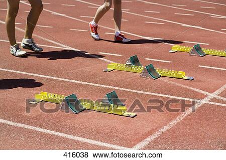 Men standing behind starting blocks at the beginning of a race View Large Photo Image Stock Photo - Men standing behind starting blocks at the beginning of a race. Fotosearch