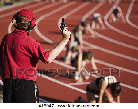 Race official holding a starting gun at the beginning of a track event View Large Photo Image Stock Photo - Race official holding a starting gun at the beginning of a track event. Fotosearch