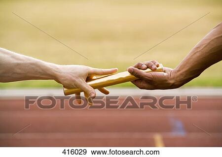 Stock Photo - Two athletes exchanging a baton during a relay race. Fotosearch