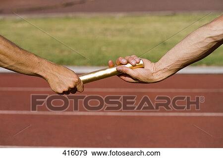 Two athletes exchanging a baton during a relay race View Large Photo Image Stock Photo - Two athletes exchanging a baton during a relay race. Fotosearch