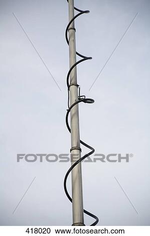 Stock Image - Metal post with cable spiraling around. Fotosearch
