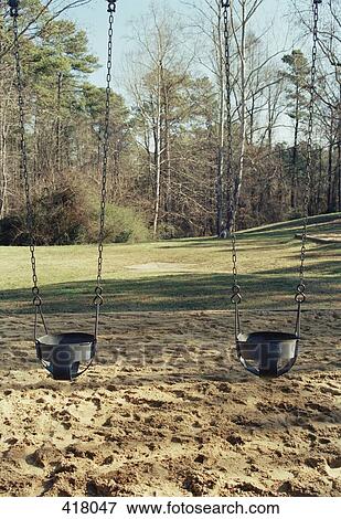 Two children's swings in the park View Large Photo Image Stock Photo - Two children's swings in the park. Fotosearch
