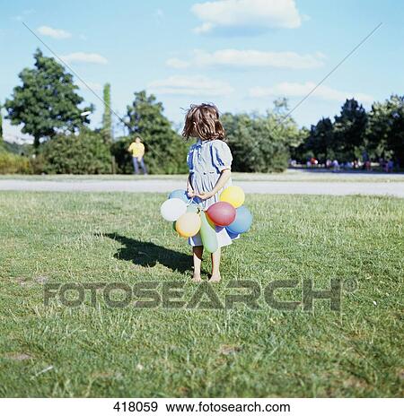 Young girl holding balloons View Large Photo Image Stock Photo - Young girl holding balloons. Fotosearch