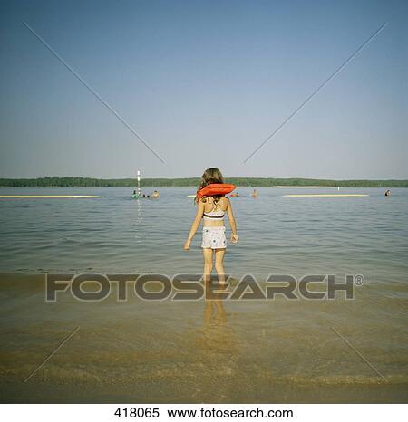 Stock Photography - Young girl standing in a lake. Fotosearch