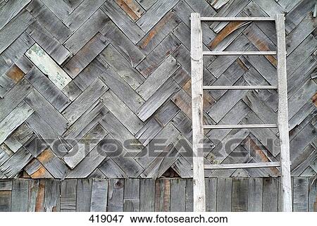 Ladder leaning against a wooden fence View Large Photo Image Stock Photo - Ladder leaning against a wooden fence. Fotosearch